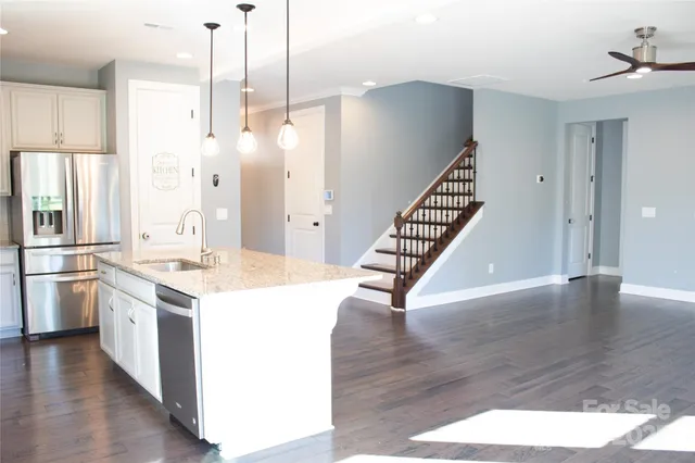 a kitchen with stainless steel appliances a stove refrigerator and wooden floor