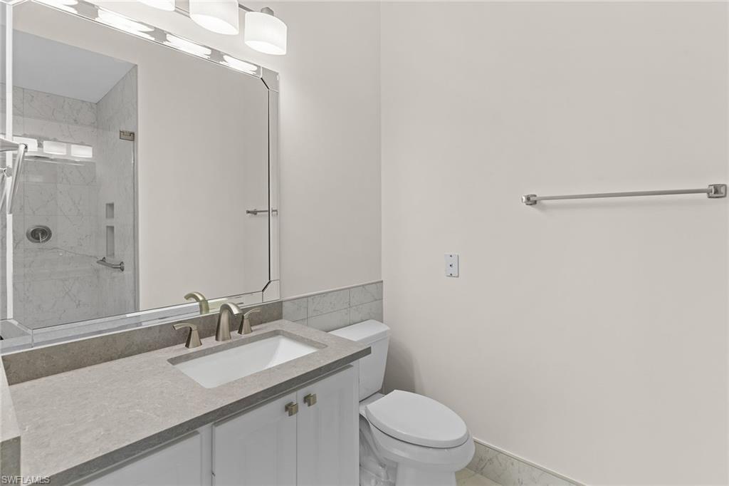 3128 Dominica Way Naples, FL 34119 - Photo 20 of 45 a bathroom with a sink a toilet a mirror and shower