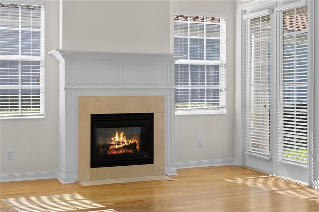 3128 Dominica Way Naples, FL 34119 - Photo 5 of 45 a living room with a fireplace and a table