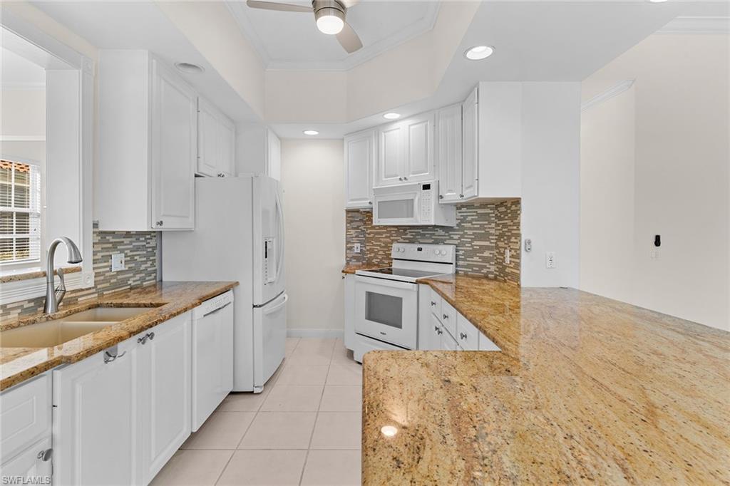 3128 Dominica Way Naples, FL 34119 - Photo 9 of 45 a large kitchen with kitchen island a sink stainless steel appliances and cabinets