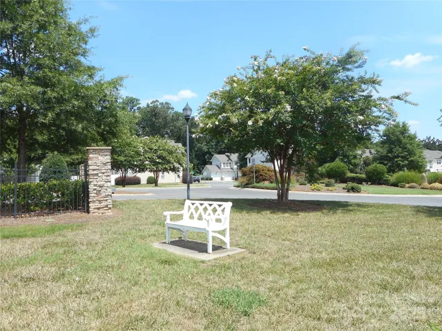 a white bench sitting in the middle of a park