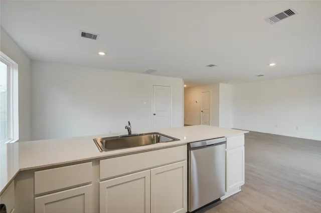 a kitchen with a sink cabinets and wooden floor