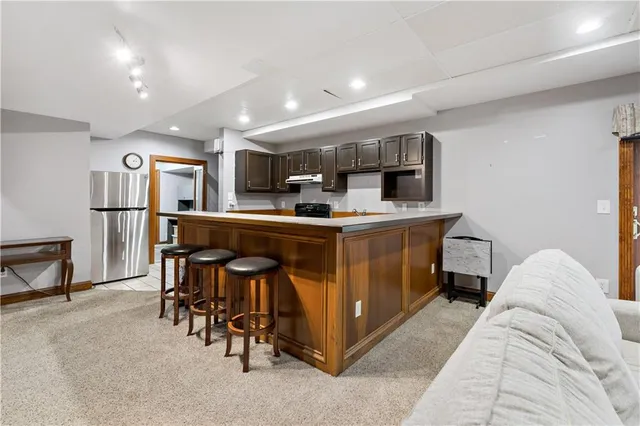 a large living room with stainless steel appliances kitchen island granite countertop furniture and a kitchen view