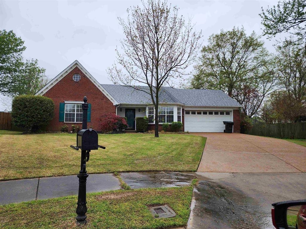 View of front facade featuring brick siding, concrete driveway, and an attached garage