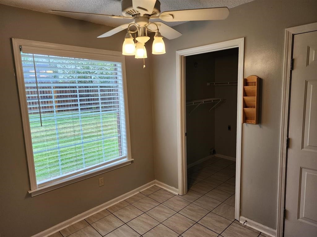 255 Windy Ridge Cove Collierville, TN 38017 - Photo 12 of 21 Unfurnished bedroom with ceiling fan, light tile patterned flooring, and a walk in closet
