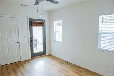 an empty room with windows closet and chandelier fan