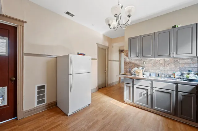 a kitchen with stainless steel appliances granite countertop a refrigerator a sink dishwasher and a stove with wooden floor