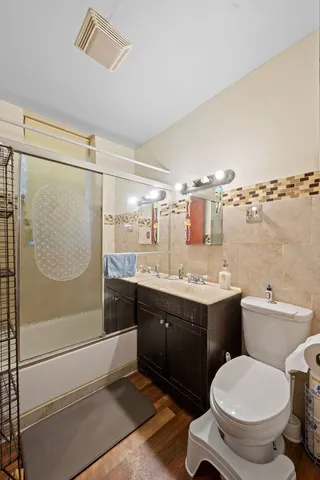 a bathroom with a granite countertop toilet sink and mirror