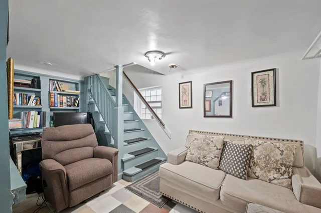 a living room with furniture and a book shelf