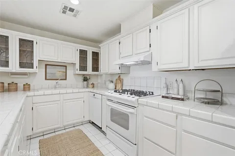 a kitchen with granite countertop a sink stove and cabinets