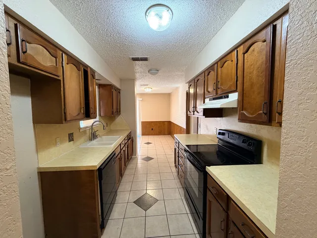 an empty room with a chandelier fan and a ceiling fan