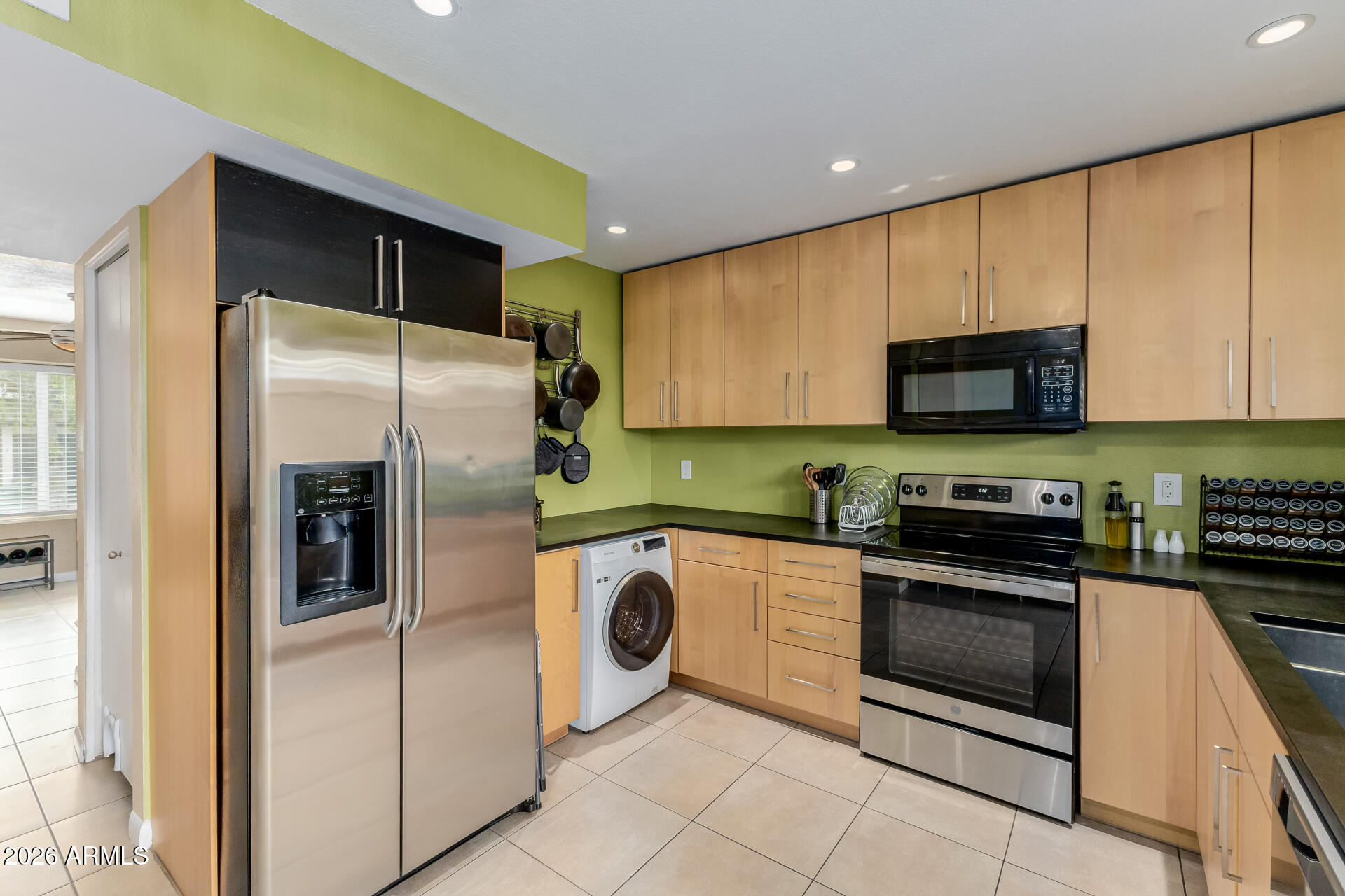 a kitchen with stainless steel appliances granite countertop a refrigerator and a stove top oven