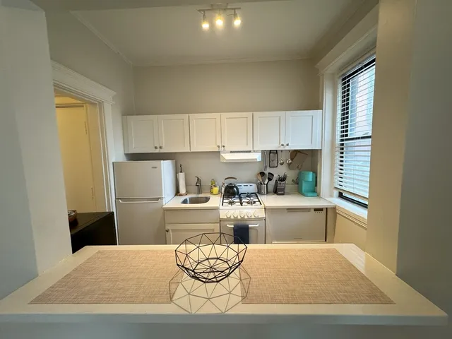 a kitchen with a refrigerator and a stove top oven