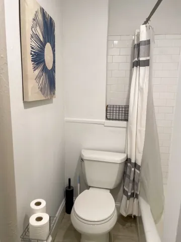 a white toilet sitting next to a shower curtain