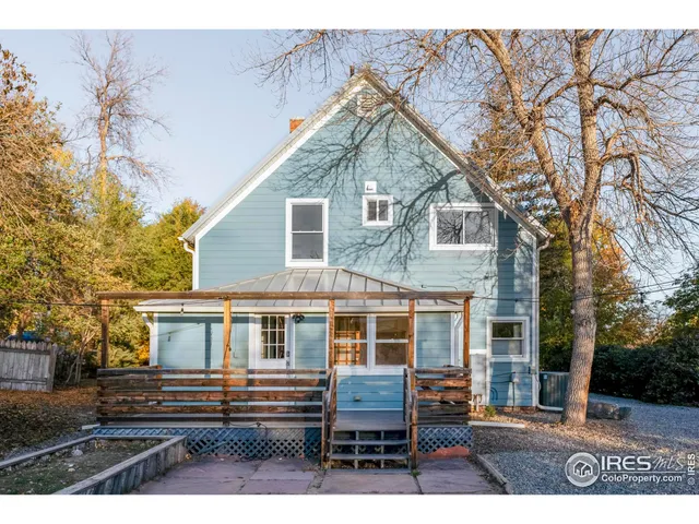 a view of a house with a backyard and trees