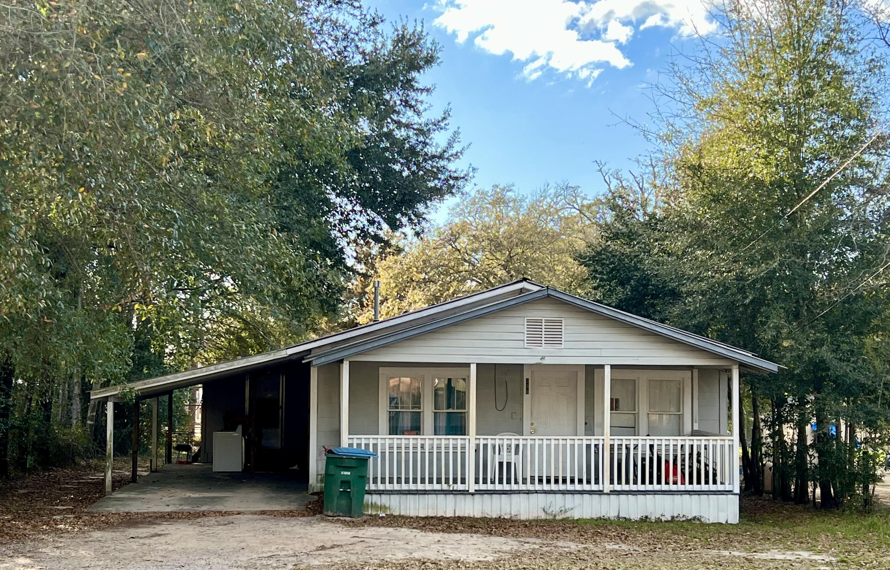 286 Lindberg Street Crestview, FL 32536 - Photo 1 of 1 a view of a brick house next to a yard with large trees