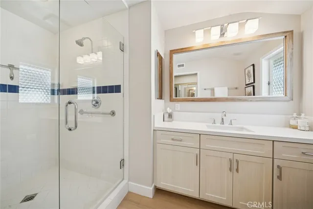 a bathroom with a double vanity sink a mirror and a shower