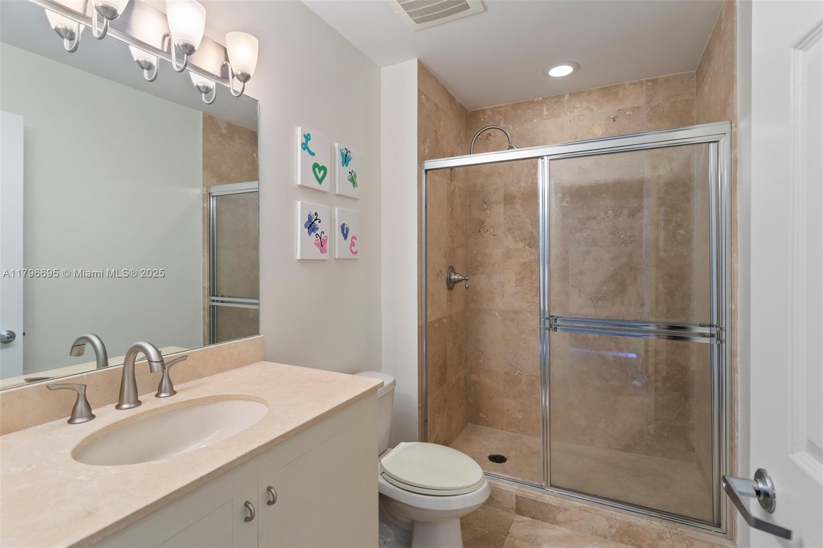 3232 Southwest 22nd Street, Unit 601 Miami, FL 33145 - Photo 15 of 38 a bathroom with a shower sink vanity mirror and toilet