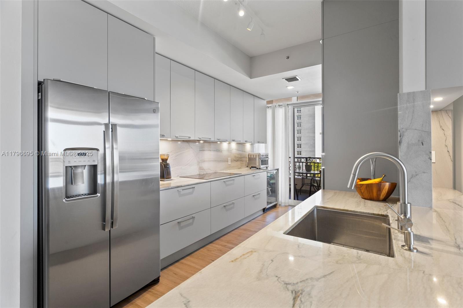 3232 Southwest 22nd Street, Unit 601 Miami, FL 33145 - Photo 5 of 38 a kitchen with stainless steel appliances granite countertop a sink a stove and refrigerator