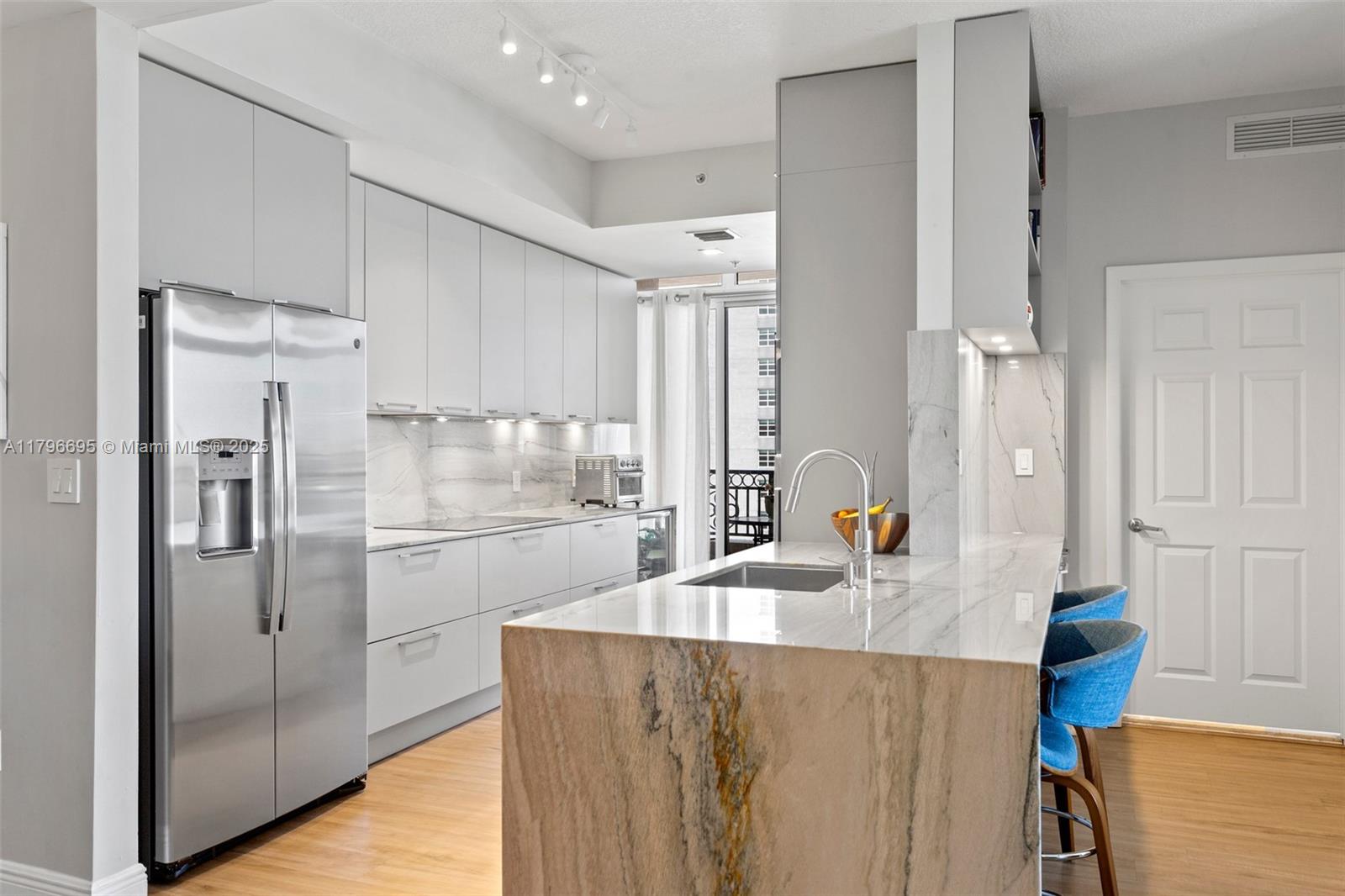 3232 Southwest 22nd Street, Unit 601 Miami, FL 33145 - Photo 7 of 38 a kitchen with stainless steel appliances granite countertop a refrigerator a sink and white cabinets