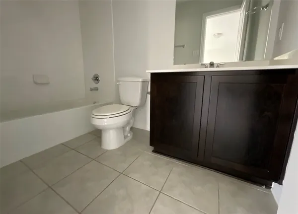 a bathroom with a granite countertop toilet a sink and a mirror