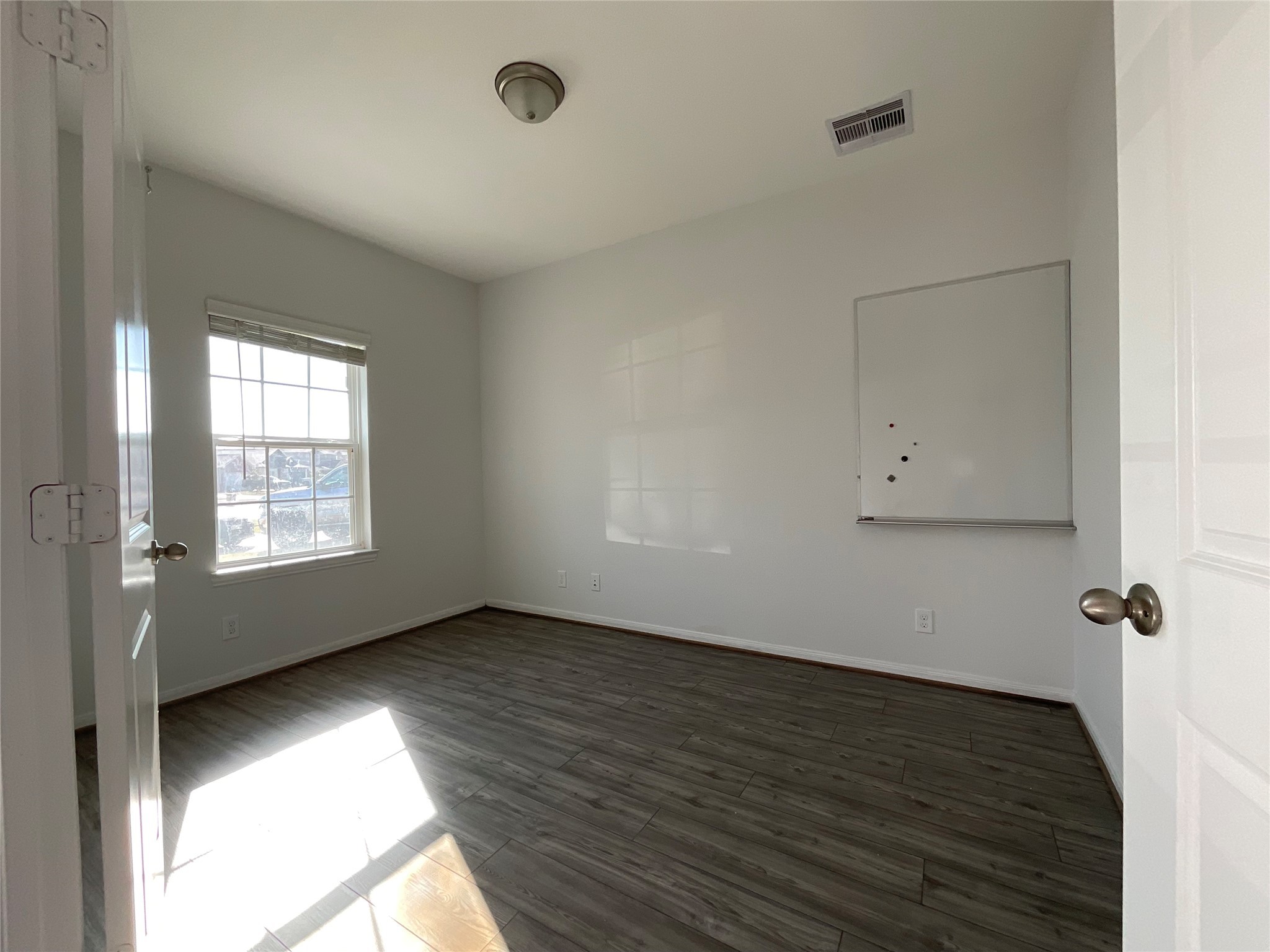 8039 Brooks Crossing Drive Baytown, TX 77521 - Photo 8 of 24 an empty room with wooden floor and windows