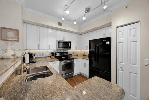a kitchen with stainless steel appliances a stove sink microwave and refrigerator