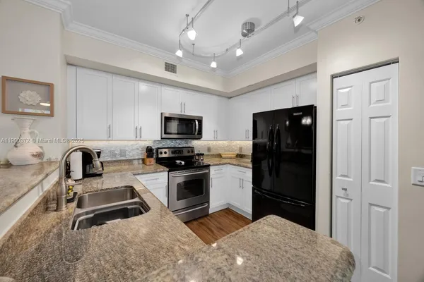 a kitchen with stainless steel appliances a stove sink microwave and refrigerator