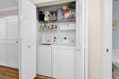 a utility room with dryer washer and a fridge