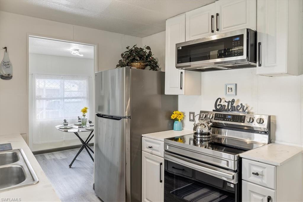 952 Days Lane North Fort Myers, FL 33917 - Photo 4 of 46 a kitchen with stainless steel appliances a stove a microwave and a refrigerator