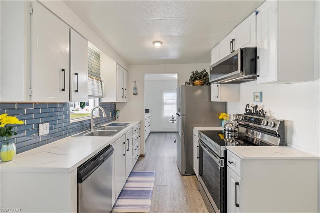 952 Days Lane North Fort Myers, FL 33917 - Photo 5 of 46 a kitchen with stainless steel appliances a sink stove top oven and cabinets