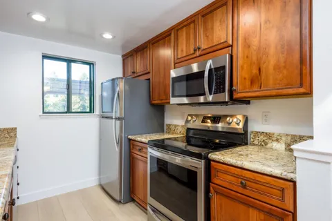 a kitchen with stainless steel appliances granite countertop a stove microwave and refrigerator