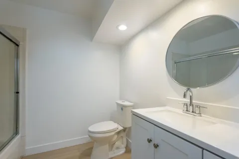 a bathroom with a toilet a sink and mirror