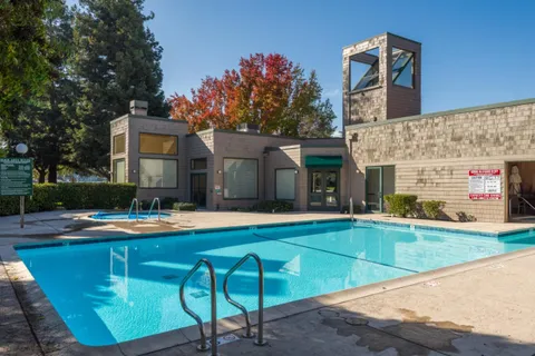 a view of a house with swimming pool and sitting area