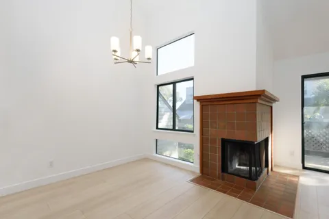an empty room with windows and fireplace