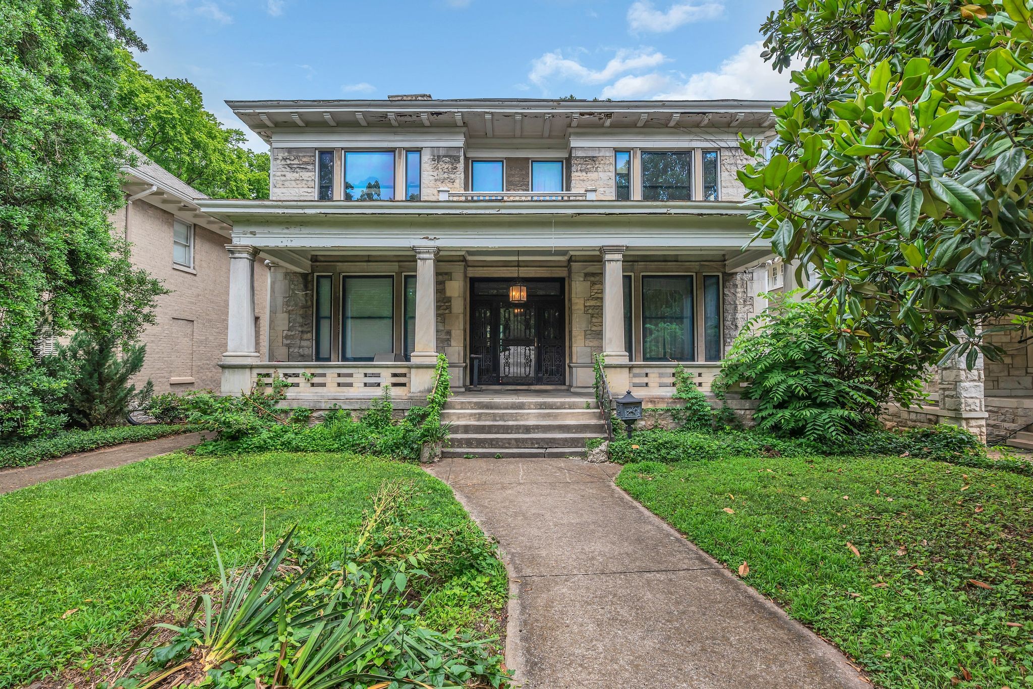 3818 Richland Avenue Nashville, TN 37205 - Photo 2 of 13 a view of a brick house with a yard plants and large tree