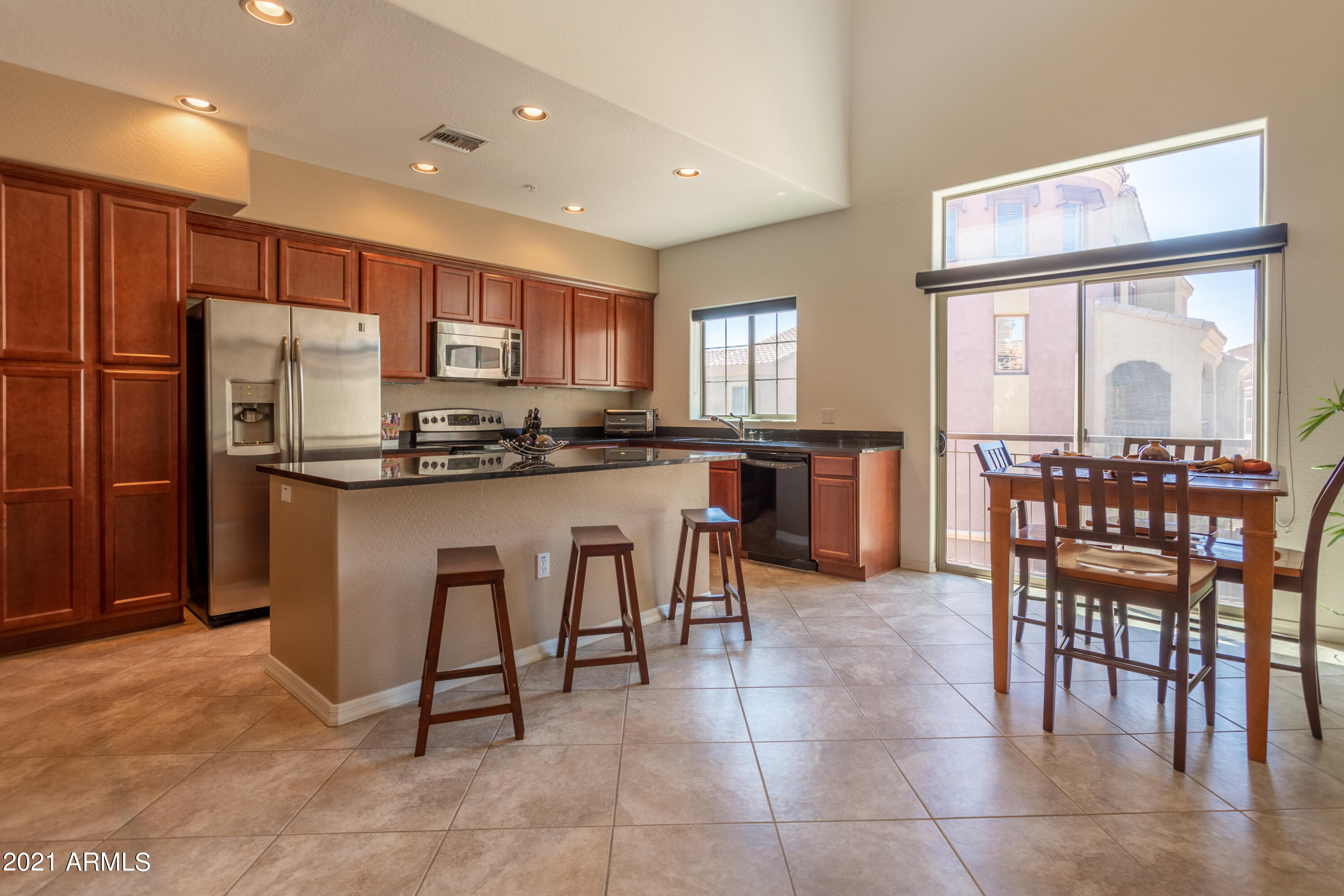 3935 East Rough Rider Road, Unit 1192 Phoenix, AZ 85050 - Photo 1 of 20 a kitchen with stainless steel appliances granite countertop a table and chairs in it