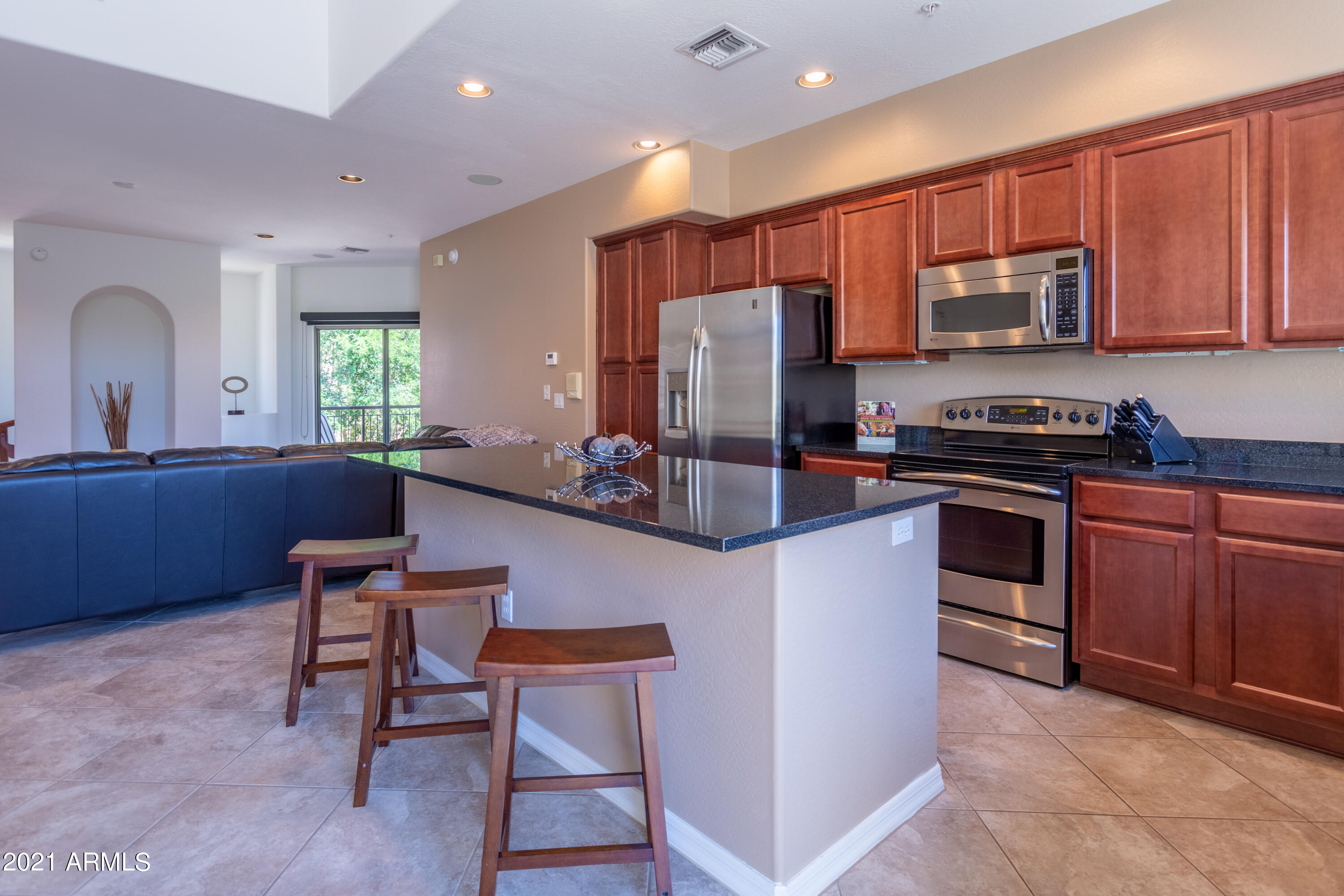 3935 East Rough Rider Road, Unit 1192 Phoenix, AZ 85050 - Photo 5 of 20 a kitchen with stainless steel appliances a stove a sink a microwave a refrigerator and chairs