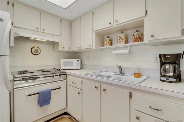 a kitchen with white cabinets and appliances