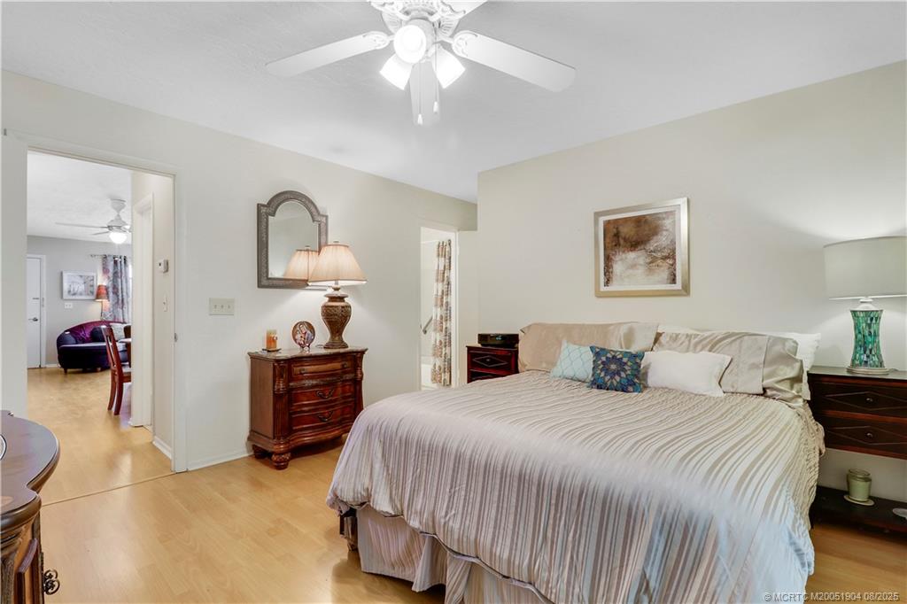 2929 Southeast Ocean Boulevard, Unit 1049 Stuart, FL 34996 - Photo 16 of 31 a bedroom with a bed and a chandelier