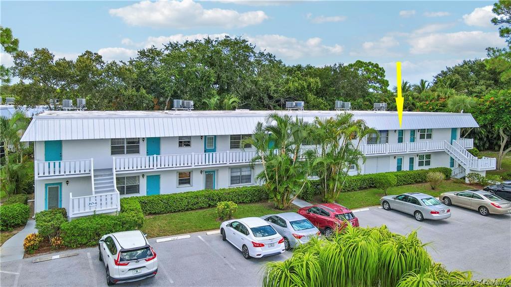 2929 Southeast Ocean Boulevard, Unit 1049 Stuart, FL 34996 - Photo 2 of 31 a front view of a house with a garden and plants
