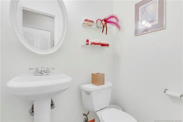 a bathroom with a sink mirror and toilet
