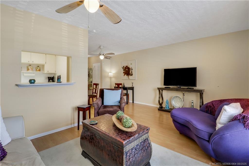 2929 Southeast Ocean Boulevard, Unit 1049 Stuart, FL 34996 - Photo 8 of 31 a living room with furniture and a flat screen tv
