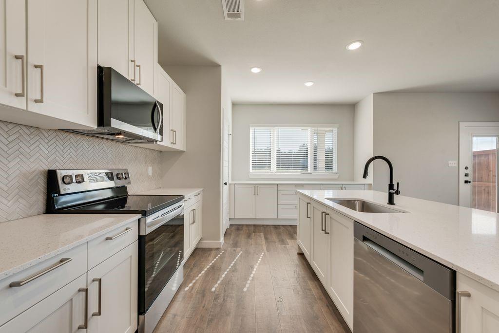 4254 Clovis Street Midlothian, TX 76065 - Photo 4 of 16 a kitchen with stainless steel appliances granite countertop a sink and a stove top oven