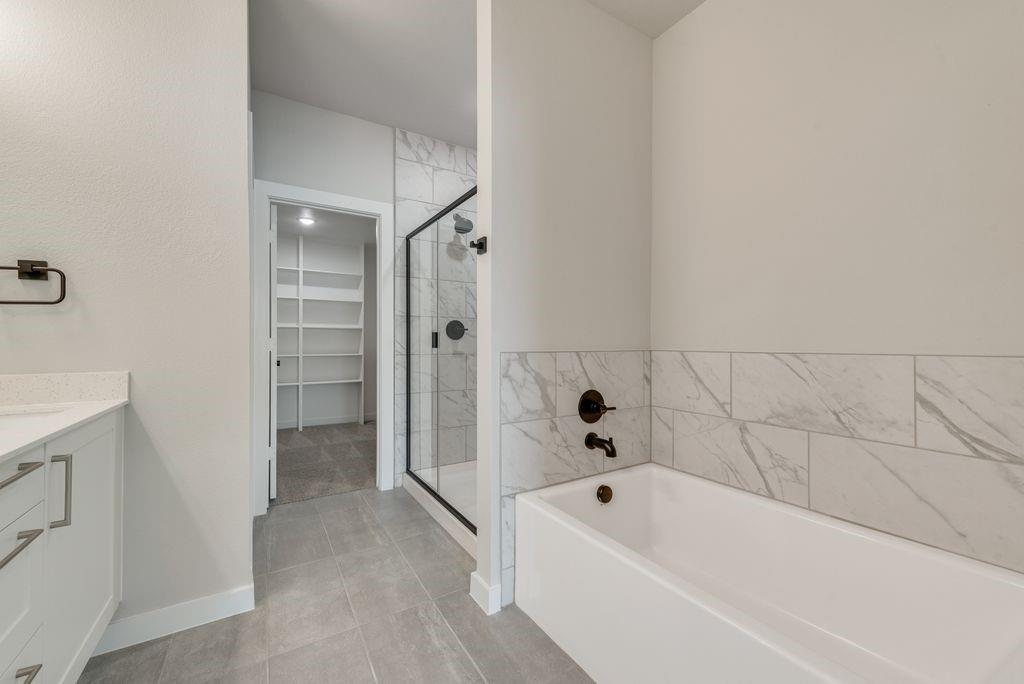4254 Clovis Street Midlothian, TX 76065 - Photo 7 of 16 a bathroom with a bathtub and a shower