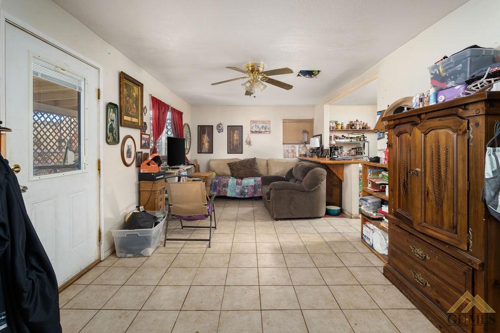 Undisclosed Address Wasco, CA 93280 - Photo 18 of 29 a living room with furniture a flat screen tv and a refrigerator