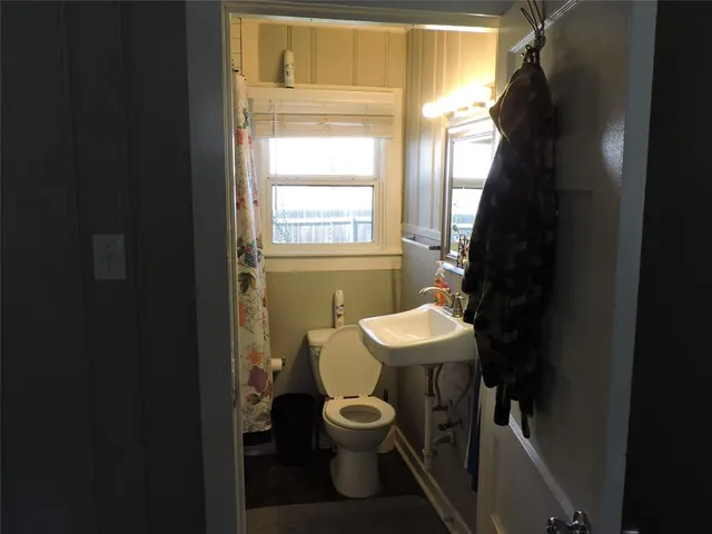 a bathroom with a toilet a sink and a window