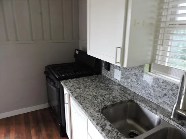 a kitchen with granite countertop a sink and a stove