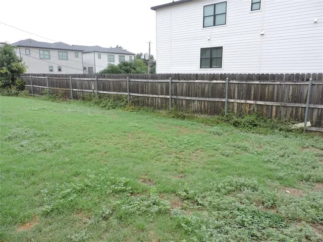 a view of an house with backyard space and wooden fence