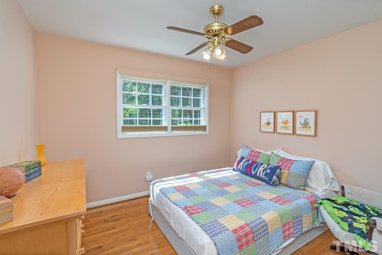 505 Old Farm Road Raleigh, NC 27606 - Photo 19 of 22 a bedroom with a bed and a chandelier